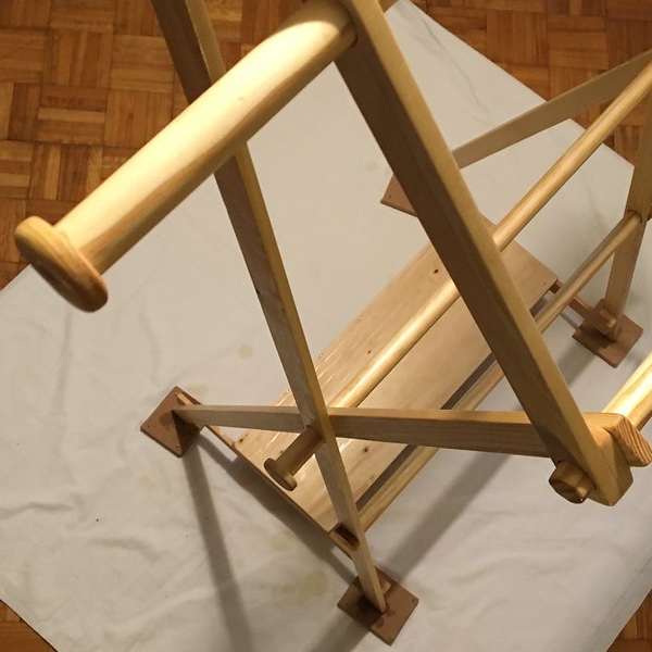 Top down view of a freshly varnished wooden valet stand standing on a dust sheet on a wooden floor